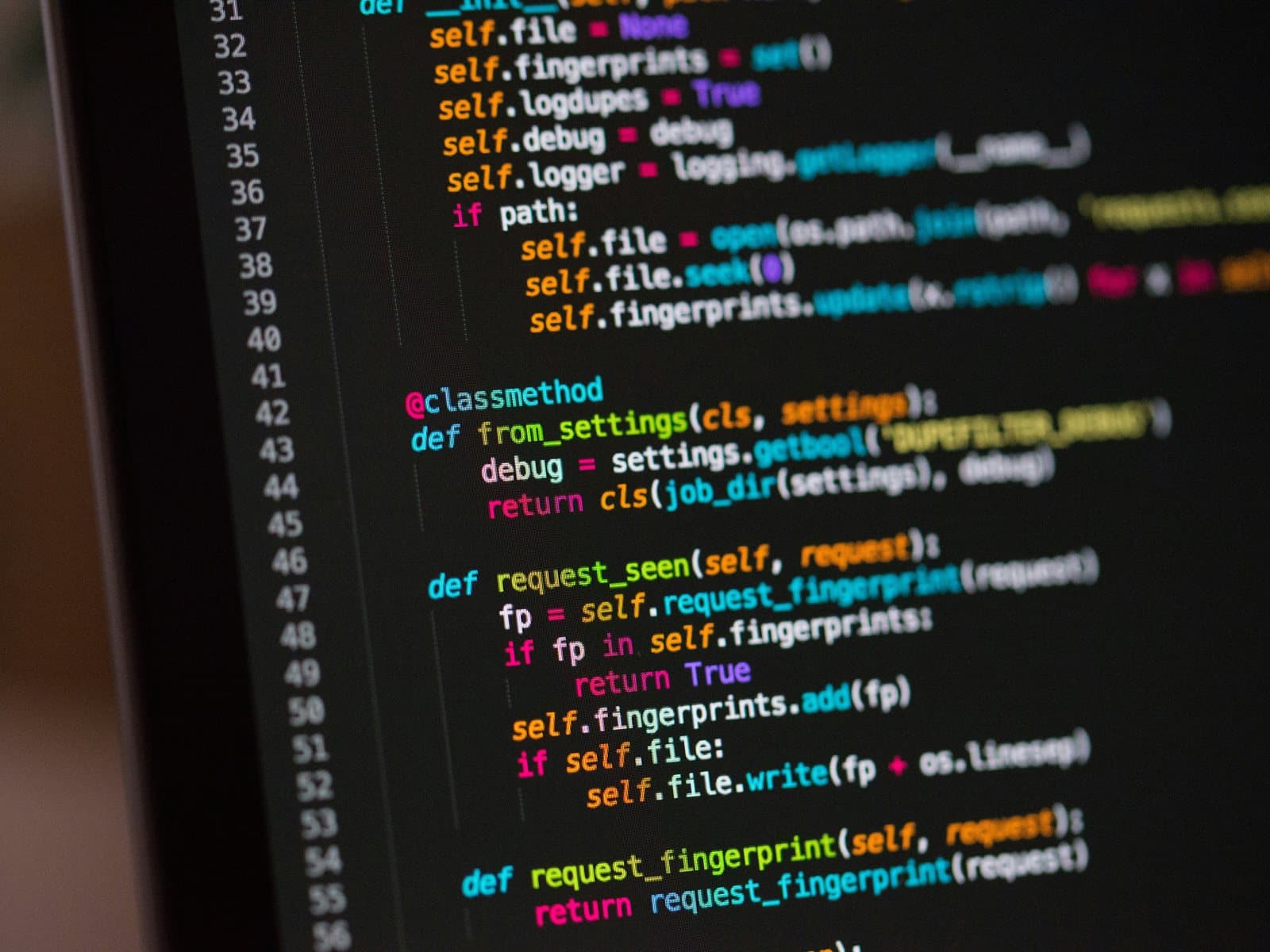 Monitor met broncode in een donkere werkruimte